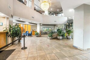 Eine geräumige Lobby mit einer Rezeption, einer Sitzecke und einer Treppe zu den oberen Etagen.