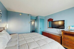A hotel room with a bed, a television, a dresser, and a door leading to a bathroom. - The Patricia Grand 1804 (Myrtle Beach)