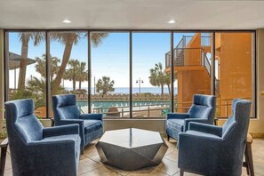 A room with large windows, a pool, and a view of a building with a staircase. - The Patricia Grand 1804 (Myrtle Beach)