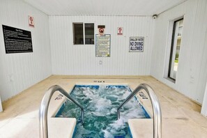 A spa pool with a hot tub, surrounded by white walls with safety and no smoking signs. - Holiday Towers Unit 205 (Myrtle Beach)