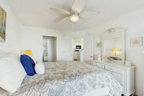 A bedroom with a bed, a ceiling fan, a dresser, and a mirror. - Carolina Yacht Landing E-13 (Little River)