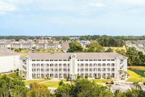 Un hôtel à plusieurs étages doté d’une cour intérieure, entourée de verdure et d’autres bâtiments.