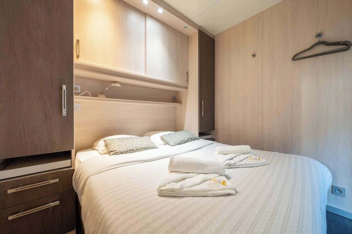 Een slaapkamer met een bed, een garderobe en een kledingroede.