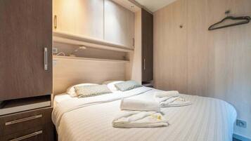 Een slaapkamer met een bed, een garderobe en een kledingroede.