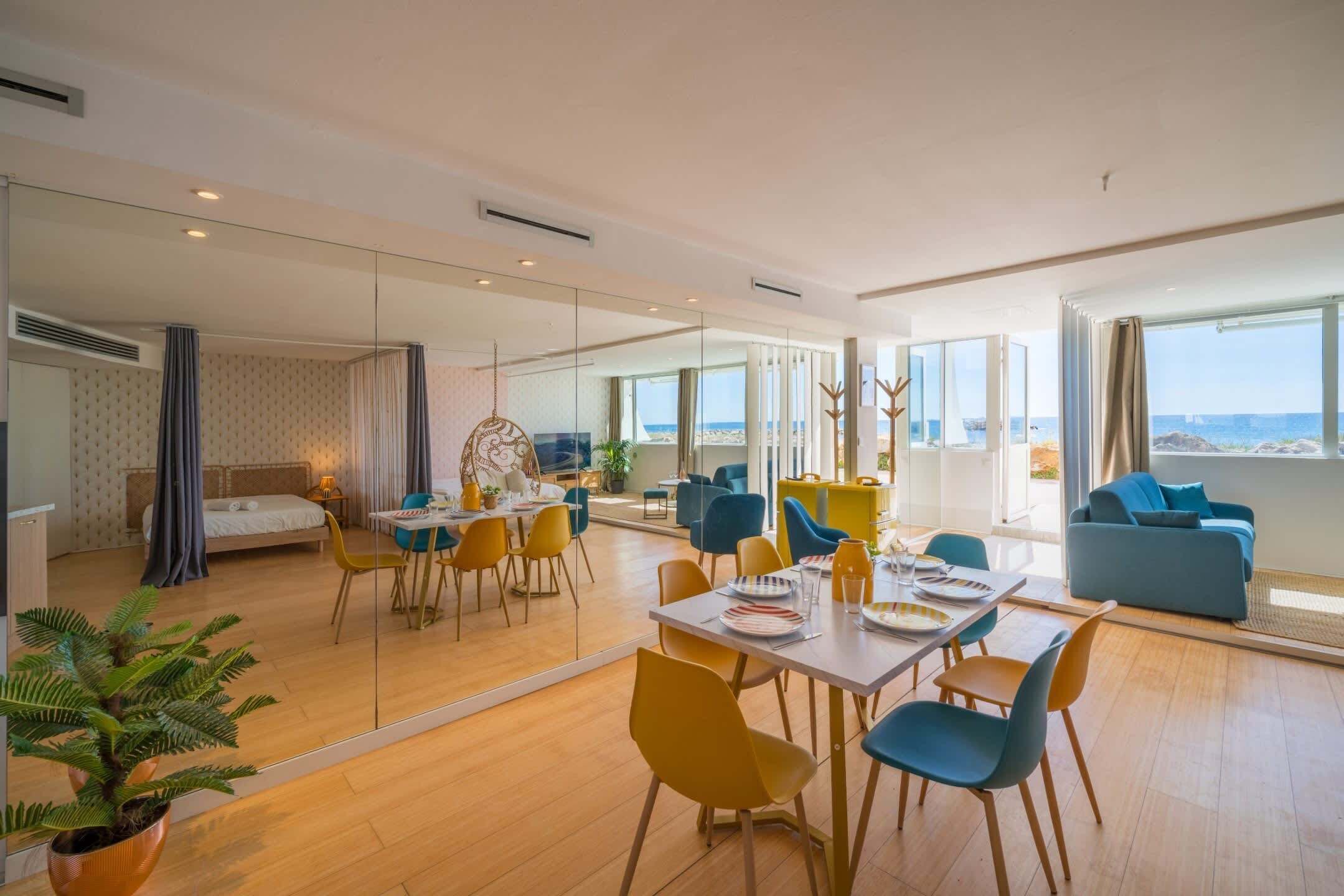 Een moderne hotelkamer met een zithoek, een bed en uitzicht op zee.