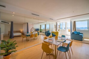 Une chambre d’hôtel moderne avec un coin repas, un lit et une vue sur la mer.