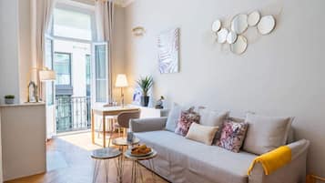 Ein Wohnzimmer mit einer Couch, einem Couchtisch und einem Essbereich mit Tisch und Stühlen.