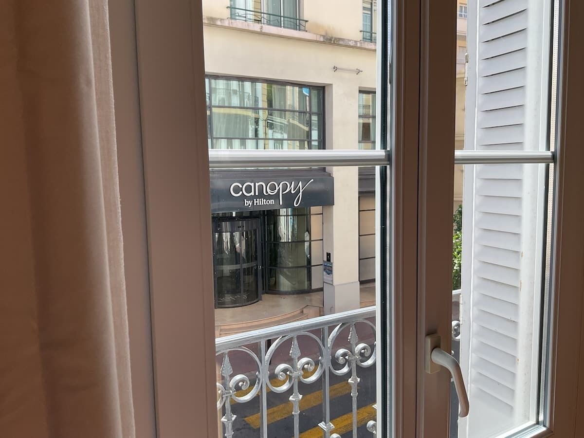 Ein Hotel Eingang mit einer Drehtür und einem Schild für 'canopy by Hilton'.