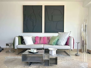 A modern living room with a sectional sofa, a coffee table, and two abstract paintings on the wall. - Riviera rooftop - front de mer avec terrasse (Antibes)