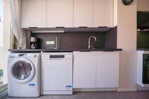 A compact kitchen with a washing machine, a dishwasher, and a sink. - Bel Azur (Antibes)