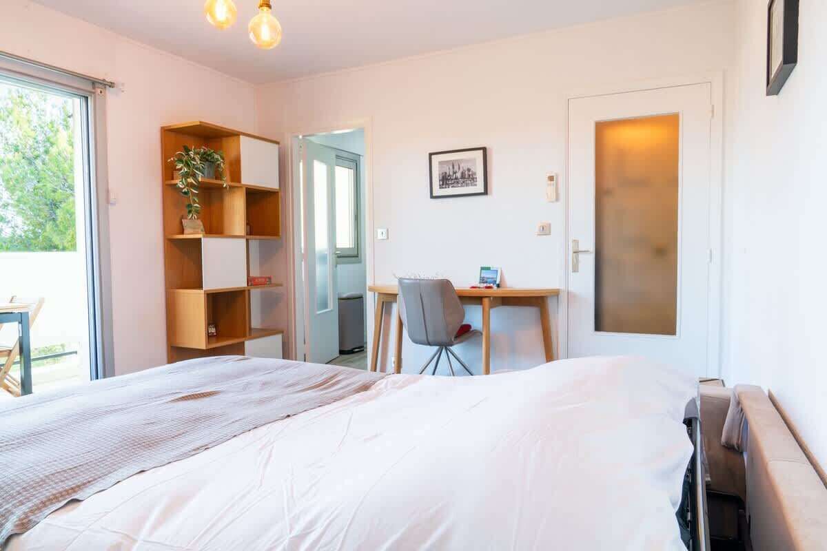 A bedroom with a bed, a desk, a chair, and a bookshelf.