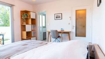A bedroom with a bed, a desk, a chair, and a bookshelf.