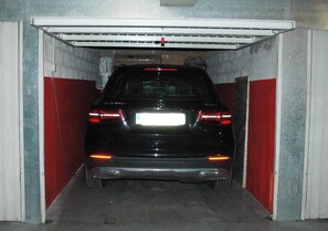 Ein schwarzes Auto steht in einer Garage mit roten und weißen Wänden.