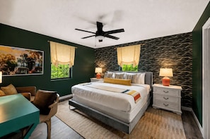 Ein Schlafzimmer mit einem Bett, Nachttischen, einem Schreibtisch und einem Stuhl.