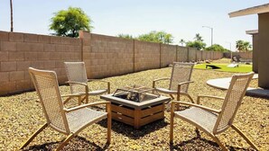 An outdoor seating area with wicker chairs and a square fire pit. - Elevated Beautiful Home Heated Pool Dog Friendly (Scottsdale)