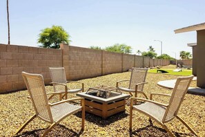 An outdoor seating area with wicker chairs and a square fire pit. - Elevated Beautiful Home Heated Pool Dog Friendly (Scottsdale)