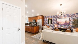 A modern kitchen with wooden cabinets, a stainless steel refrigerator, and a large island. - Elevated Beautiful Home Heated Pool Dog Friendly (Scottsdale)