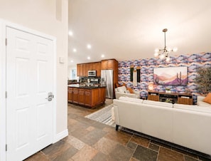 A modern kitchen with wooden cabinets, a stainless steel refrigerator, and a large island. - Elevated Beautiful Home Heated Pool Dog Friendly (Scottsdale)