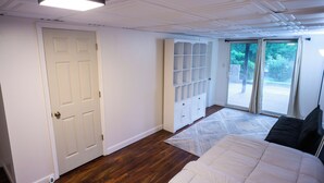 Quarto com uma cama grande, um guarda-roupa e uma porta de vidro que dá para uma varanda.