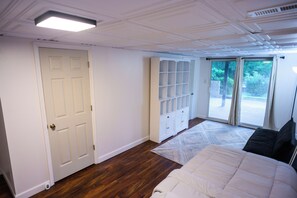 Una camera da letto con un letto grande, un armadio e una porta scorrevole in vetro che dà su un balcone.