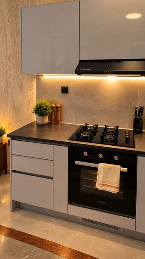 A modern kitchen with a gas stove, oven, and a built-in range hood. - Панорамный вид на океан, бухту, город. Спокойный район. Песчаный каньон. (Lazareto)