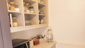 A compact kitchen with a microwave, a small refrigerator, and a trash bin. - Family Ensuite, Balcony & Bunks | Boyne Valley (Drogheda)
