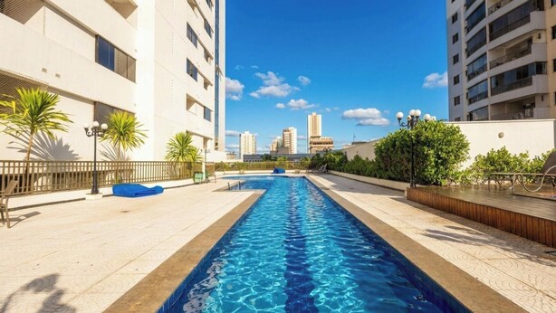 A swimming pool with a view of tall buildings in the background. - Studio in Condo w/ Pool in Setor Bueno Bli2903 (Goiânia)