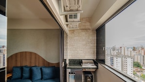 A compact living space with a built-in kitchen, a wooden headboard, and a city view. - Apt in Cond. w/ Pool in Goiania Bli1801 (Goiânia)