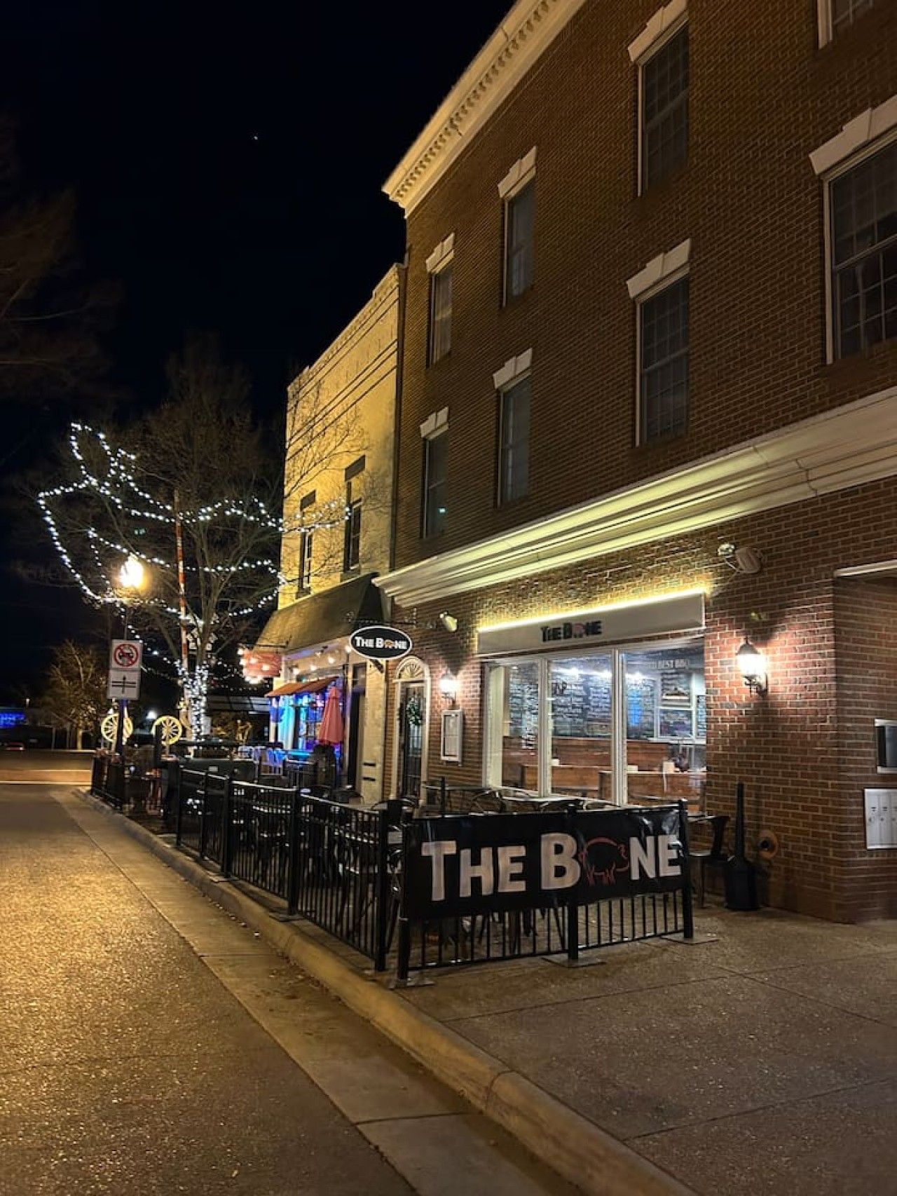 A brick building with a storefront named 'The Bone.'