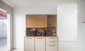 A compact kitchen with a microwave, coffee maker, and blender on a wooden cabinet. - House w/ 2 Suites in a Cond. w/ Pool Blv0002 (Porto Seguro)