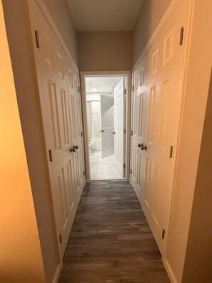 A hallway with double doors leading to a bathroom.