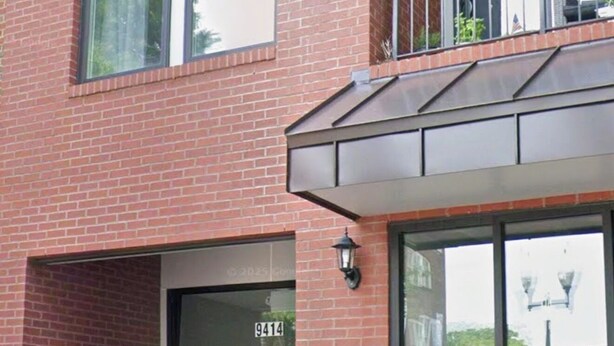 A two-story building with a brick facade, a glass entrance door, and a small balcony with a metal railing. - Old Town Manassas Sleeps 4 next to bars and restaurants ,  WALK TO VRE (Manassas)