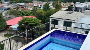 En hotellpool med namnet ”HOTEL 17” skrivet på poolens yta, omgiven av byggnader och grönska.