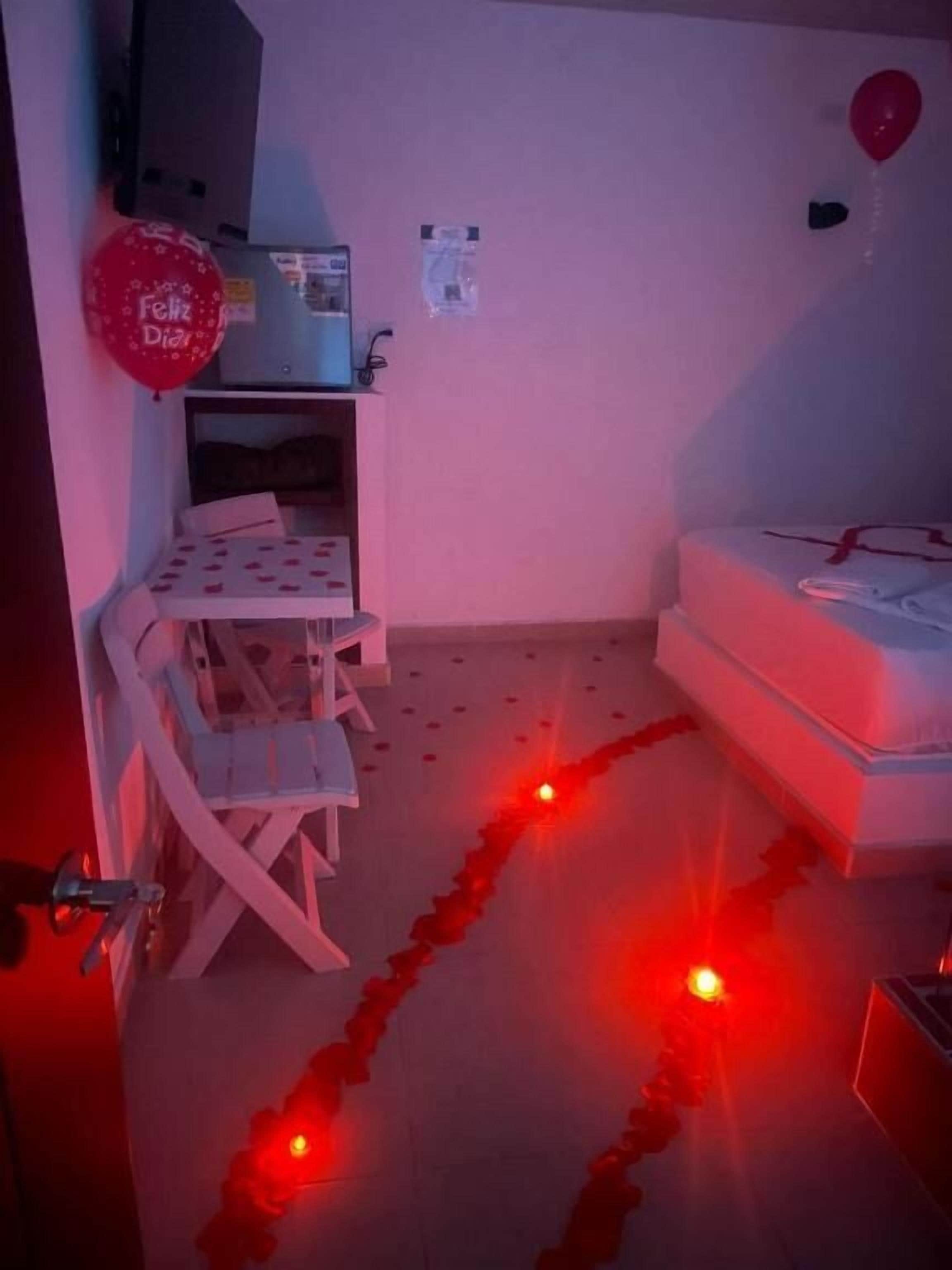 Una habitación con cama, escritorio, silla y un globo rojo.