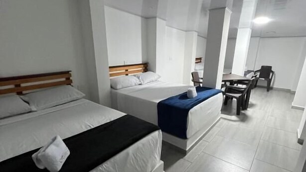 Ett hotellrum med en säng, ett skrivbord, en stol och ett litet bord.