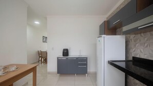 A compact kitchen with a refrigerator, a coffee maker, and a dining table with chairs. - House w/ 2 Suites in a Cond. w/ Pool Blv0004 (Porto Seguro)