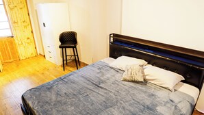 Ein Schlafzimmer mit einem Bett, einem Sessel und einem Kleiderschrank.