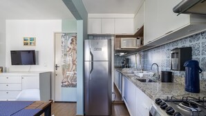 Une cuisine moderne équipée d’un réfrigérateur en acier inoxydable, d’un four à micro-ondes, d’une machine à café et d’une cuisinière à gaz.
