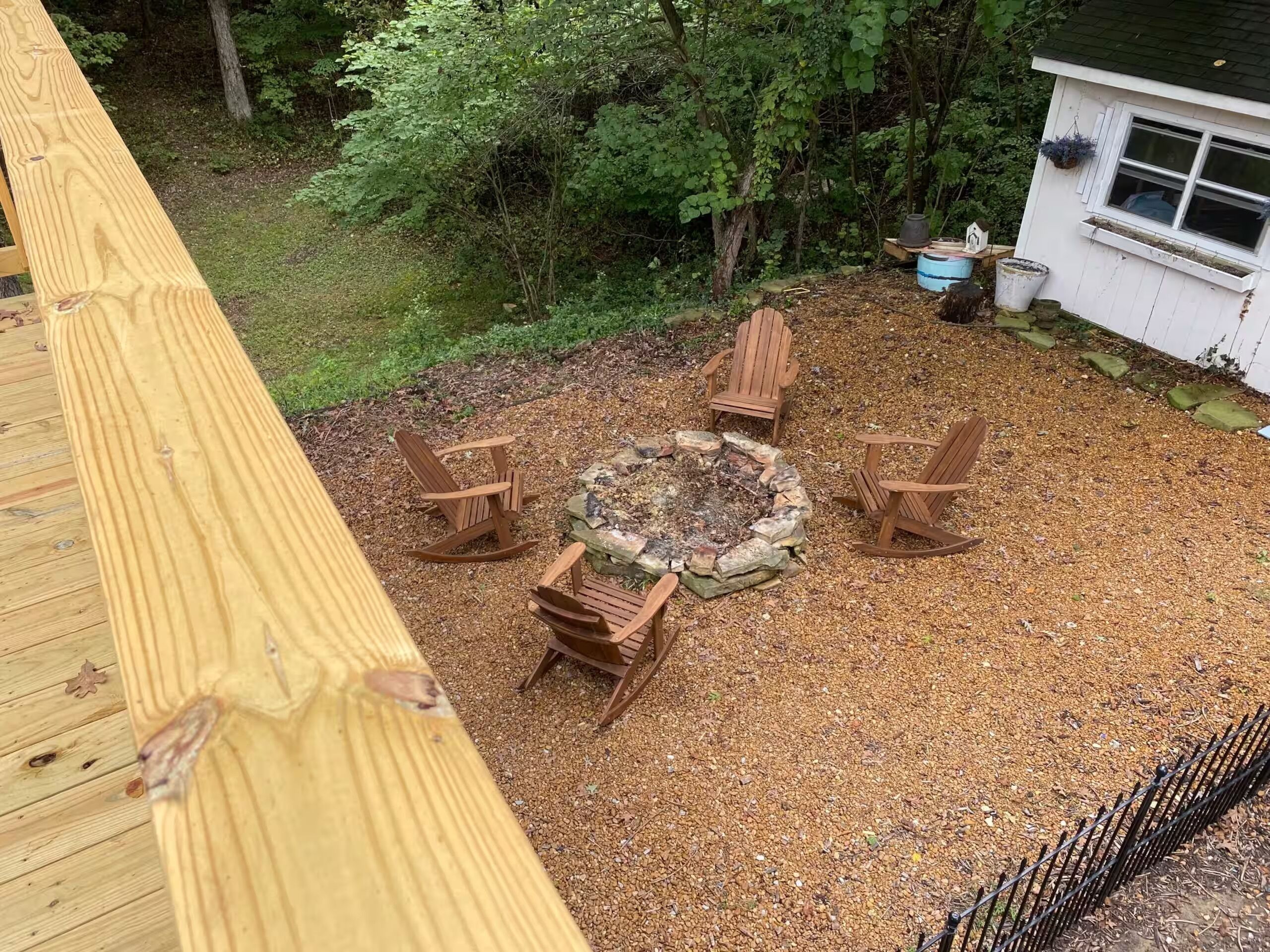 Une terrasse avec un foyer et quatre chaises Adirondack.