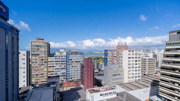 A cityscape with high-rise buildings, some with visible signage, and a clear sky. - Apt in Downtown Floripa Cat0905 (Florianópolis)