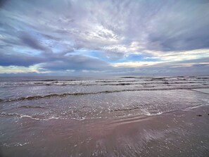 A beach with waves and a cloudy sky. - Casa Pelicano - Gulf Views (Galveston)