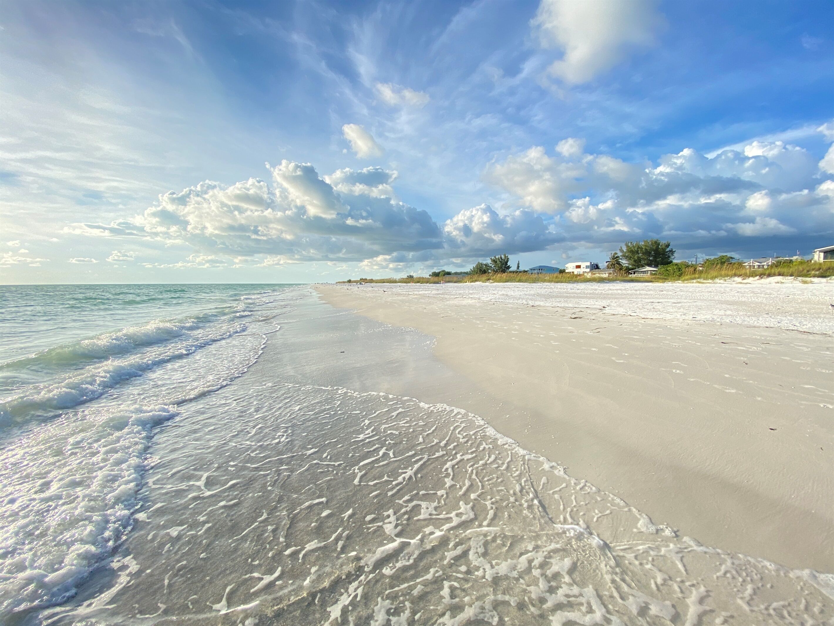 A beach with a sandy shore and gentle waves.
