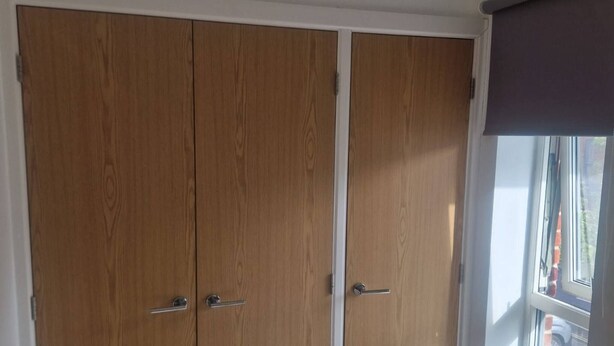 A room with a large wardrobe, a window with a view, and a hanging light fixture. - Room-a Friendly Budget Room That Deliver (Southampton)
