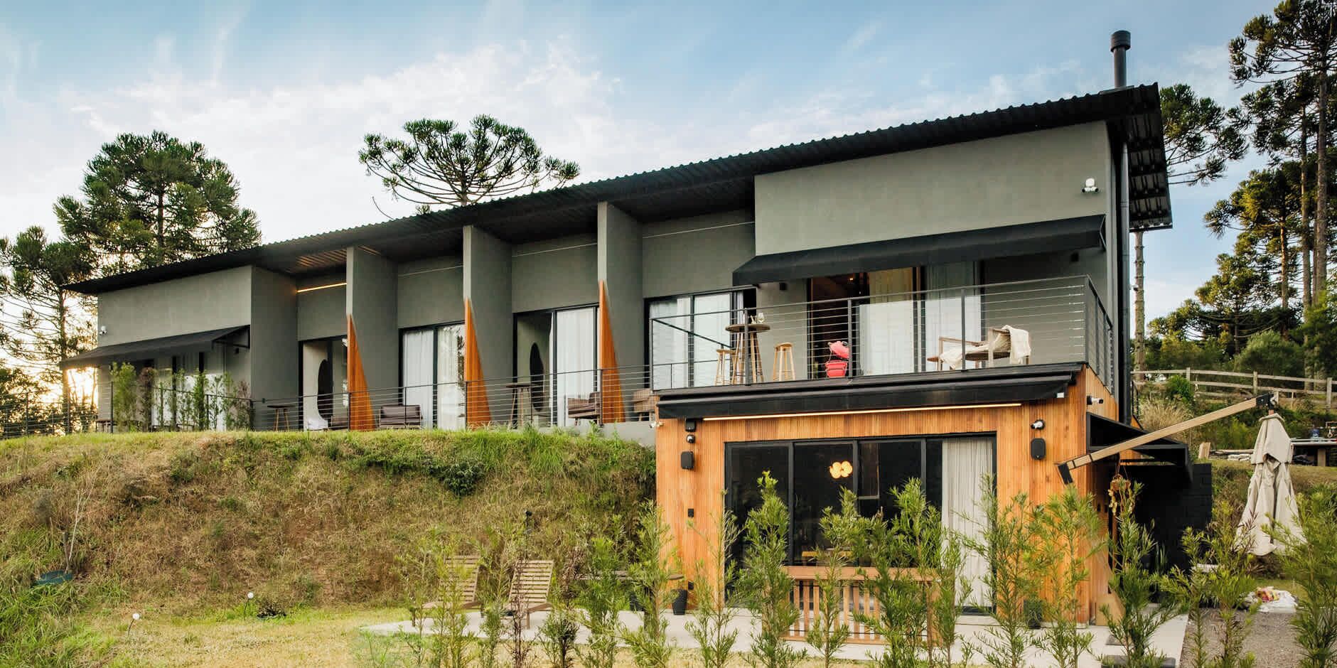 Un bâtiment moderne à plusieurs étages, doté d’un toit plat, de grandes fenêtres et d’une terrasse en bois.