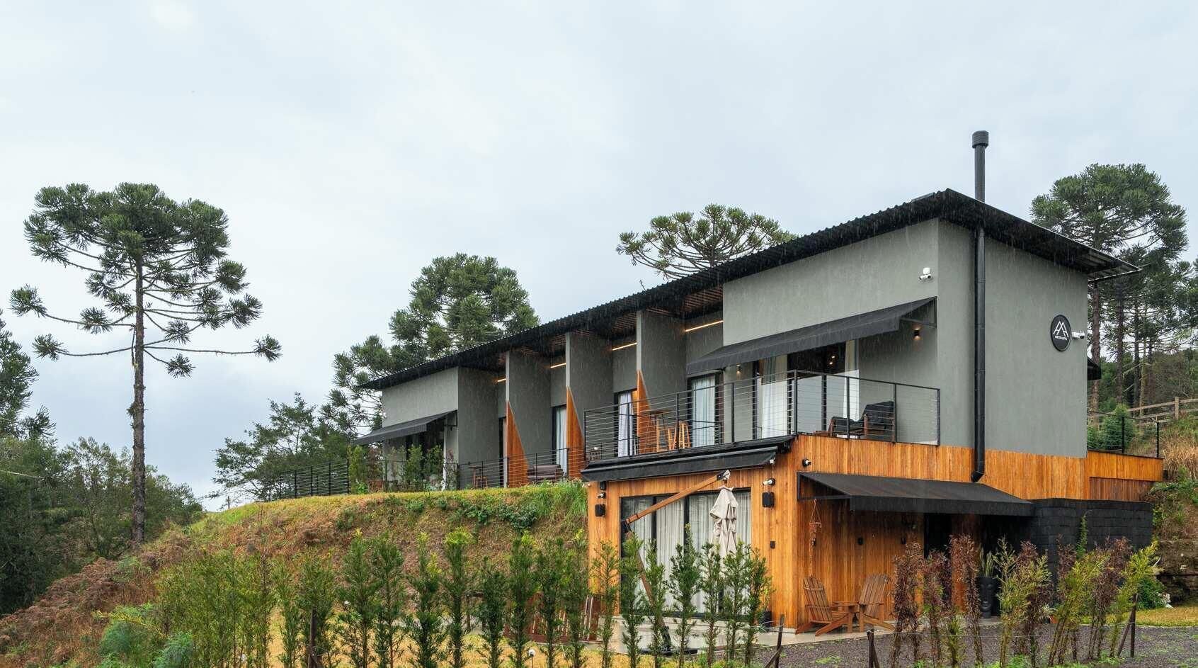 A modern two-story building with a flat roof, large windows, and a balcony.