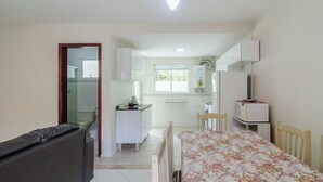 A compact hotel room with a kitchenette, a dining area, and a small bathroom. - 2BR House w/ BBQ 150m From Beach Ccm0008 (Bombinhas)