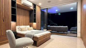 Um quarto moderno com uma cama grande, uma escrivaninha e uma varanda com área de estar.