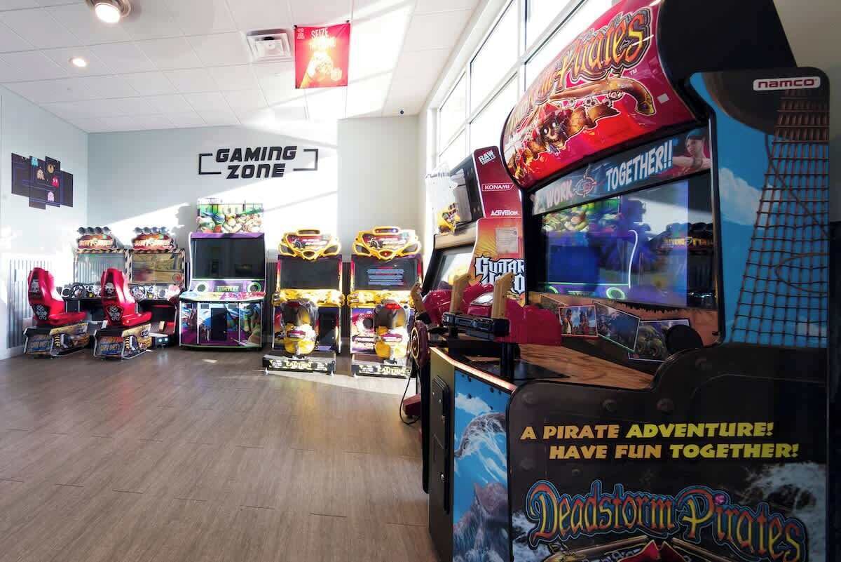 An indoor gaming area with arcade machines, including a 'Pirates' game, and a 'Gaming Zone' sign.