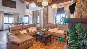 A cozy living room with a sectional sofa, a coffee table, and a fireplace. - Villa Ana Manuela El Gastor by Ruralidays (Cádiz)