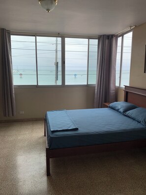 A bedroom with a bed, a window, and a view of the sea. - Adorable 3-bedroom, 2.5 bath apartment with a balcony overlooking the ocean. (Salinas)